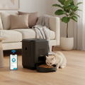 Cat eating from smart pet feeder on wooden floor